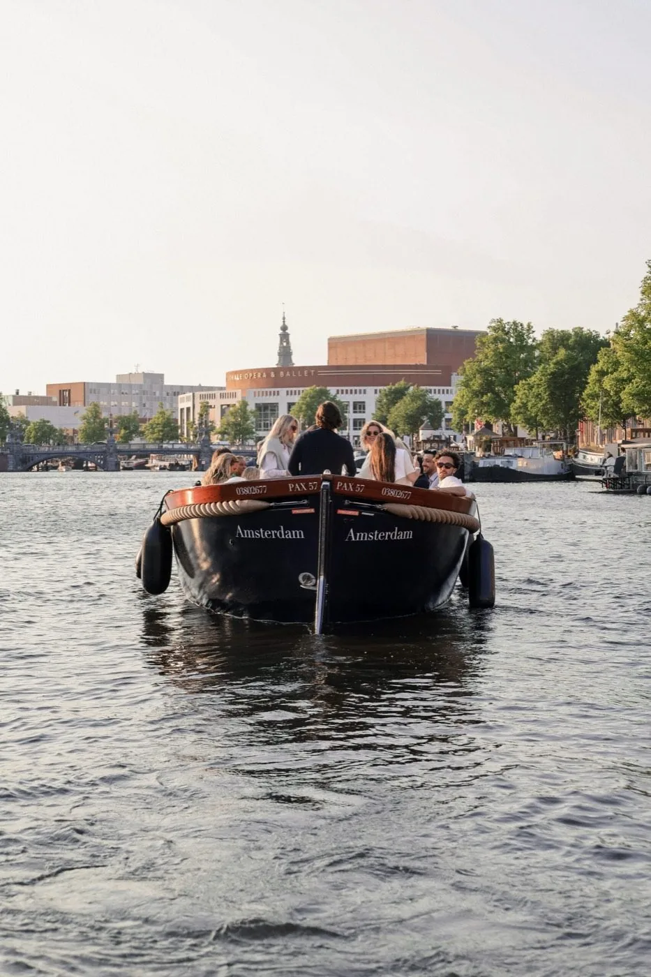 Groep gasten geniet aan boord van een privé sloep op de Amsterdamse grachten