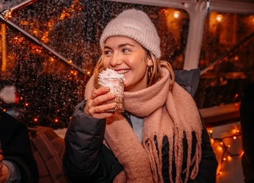 Gast met warme chocolademelk en slagroom aan boord tijdens een winteravond
